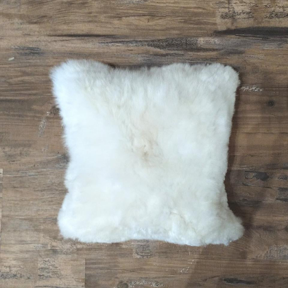 white fluffy pillow laying on wood floor