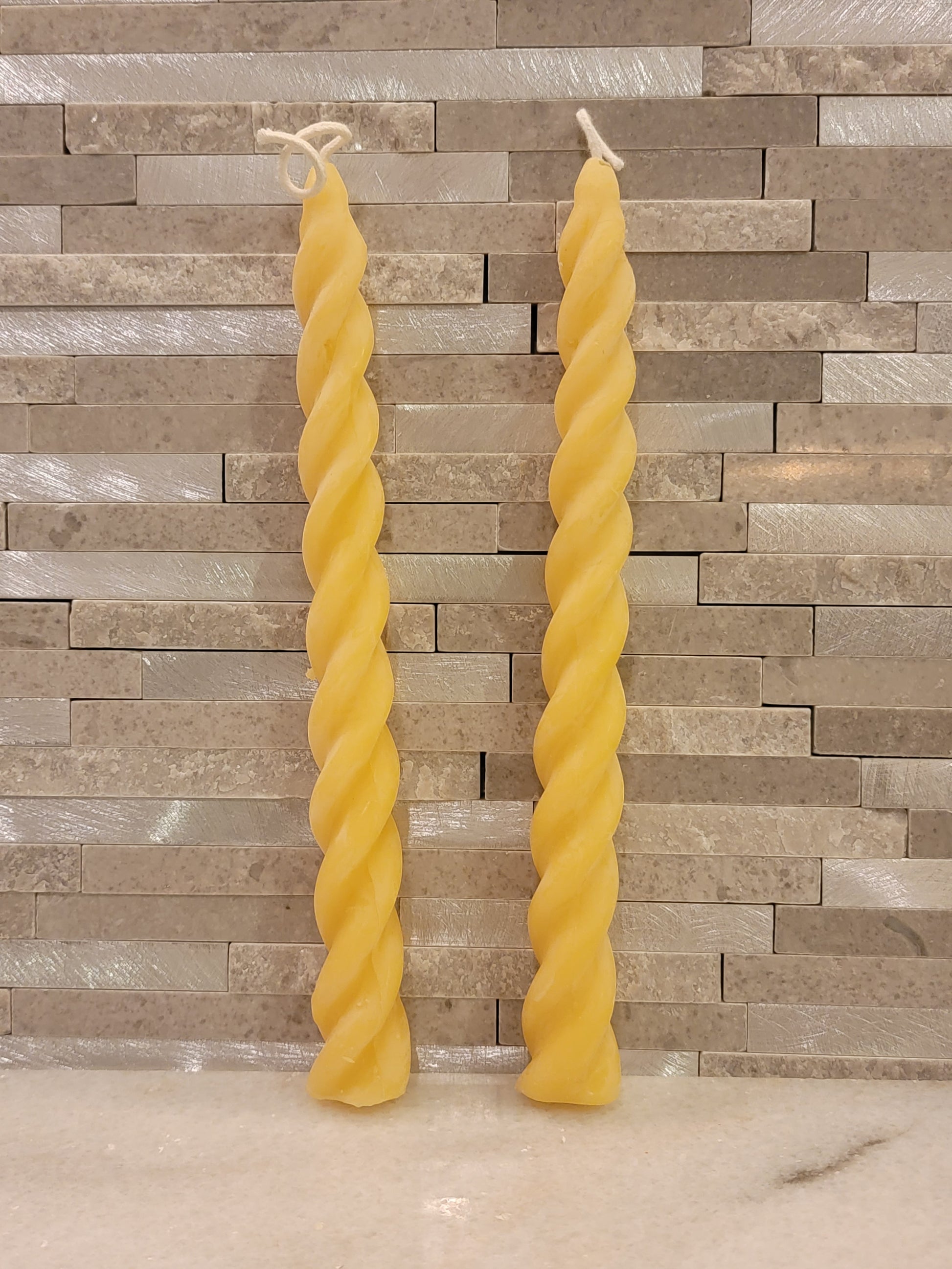 two thin twisted pillar candles