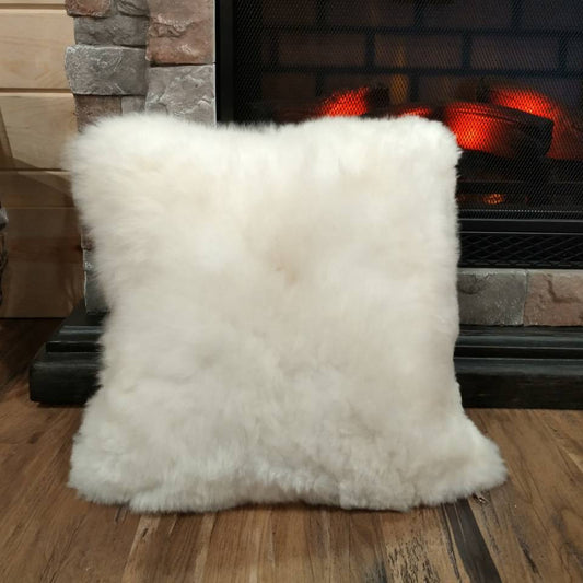 a white fluffy pillow by a fire place